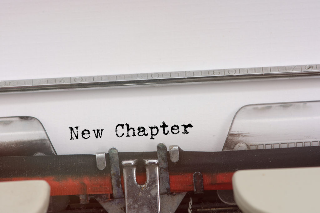 Vintage typewriter with "New Chapter" types out. Reminder for Over 50 women starting a new chapter. 