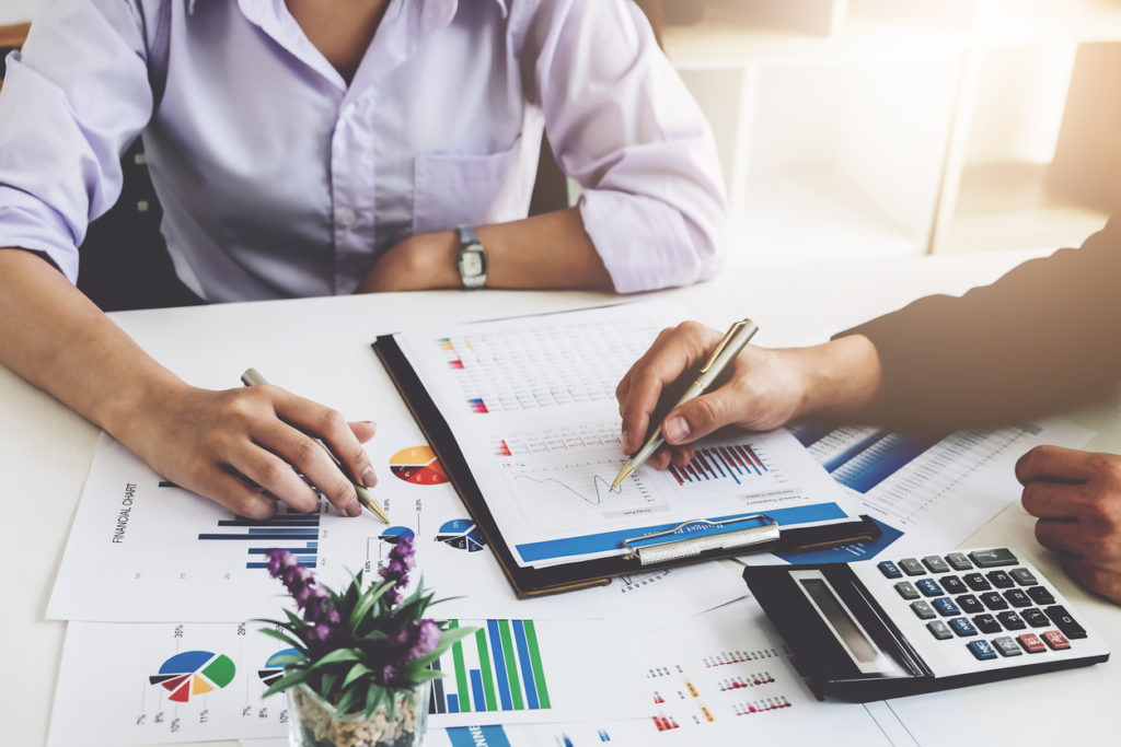 Over 50 woman reviewing finances at desk with accountant. 