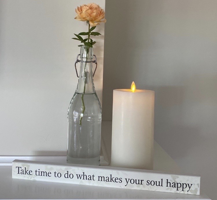 Reminder that starting over is about choices. Serene view of single rose, candle and sign "Take time to do what makes your soul happy>"